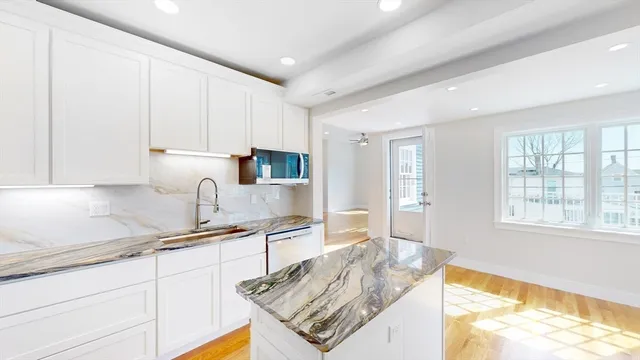 a kitchen with stainless steel appliances granite countertop a sink stove and cabinets