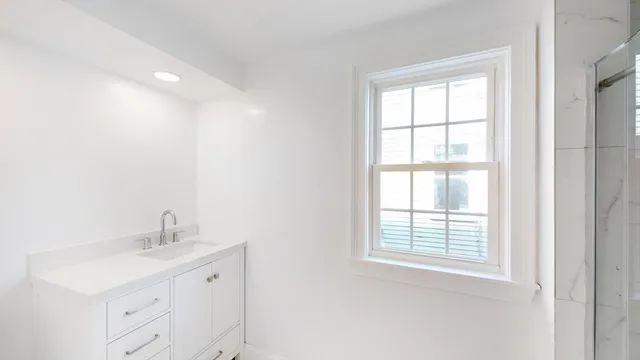 a bathroom with a sink a vanity and a window
