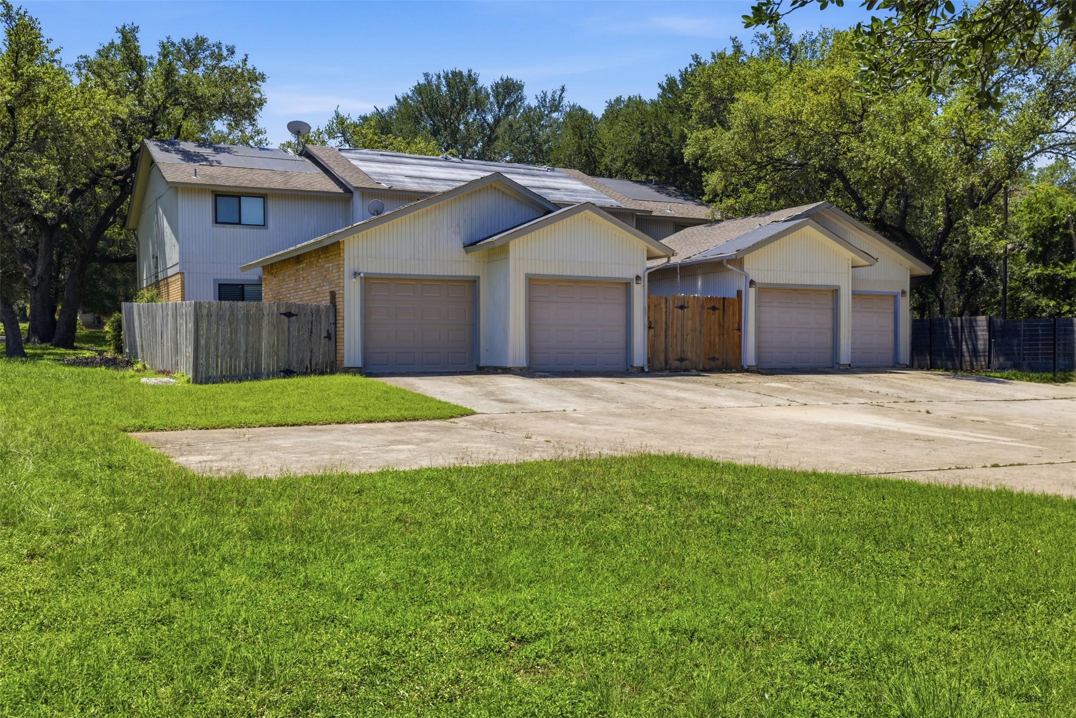 4204 Hudson Bend Road, Unit B Austin, TX 78734 - Photo 33 of 37 Multi-unit property with three attached garages, concrete driveways, and mature perimeter trees