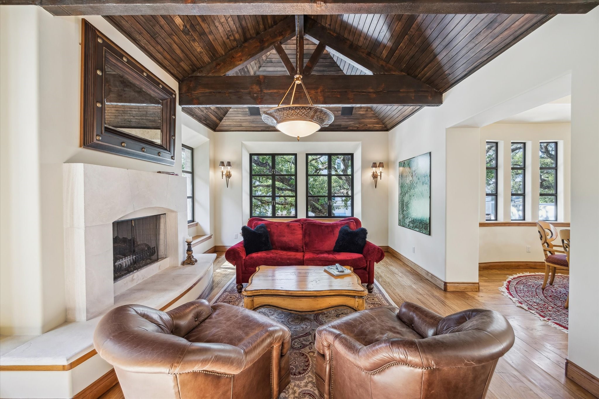 a living room with furniture a fireplace and large windows