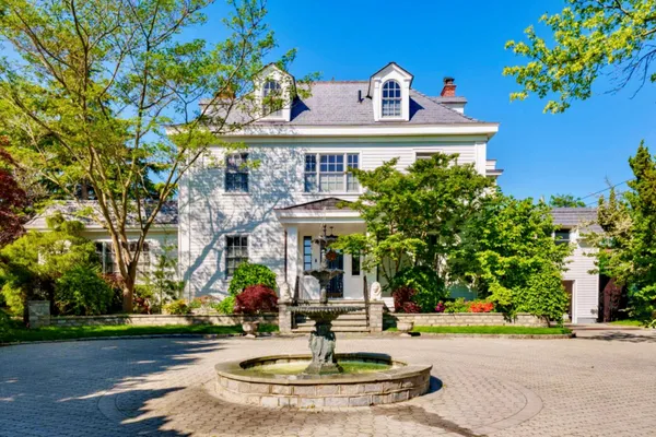 a view of a house with fountain and a tree