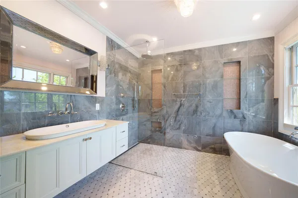 a bathroom with a sink a toilet a mirror and shower