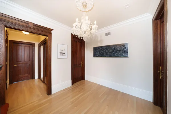 a view of a hallway with wooden floor and a large mirror