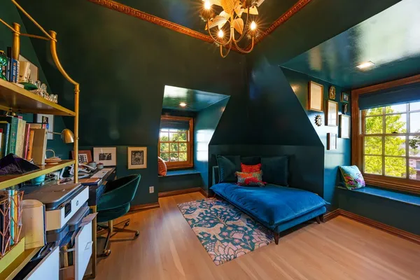 a living room with furniture a bookshelf and a window