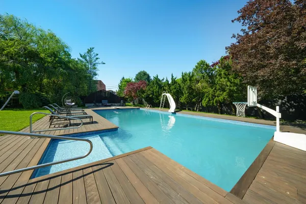 a view of a swimming pool with a patio and a yard