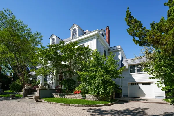 a front view of a house with a yard and tree s