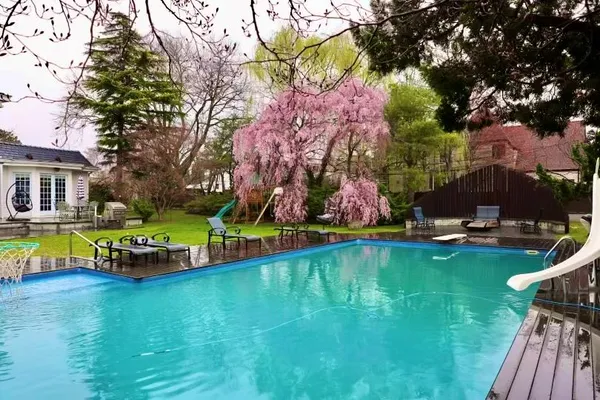 a view of swimming pool with lawn chairs and a yard