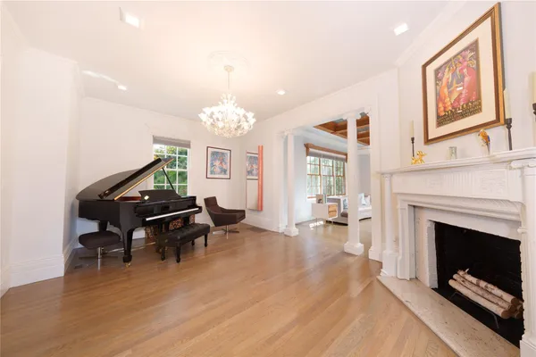a living room with furniture a fireplace and a chandelier