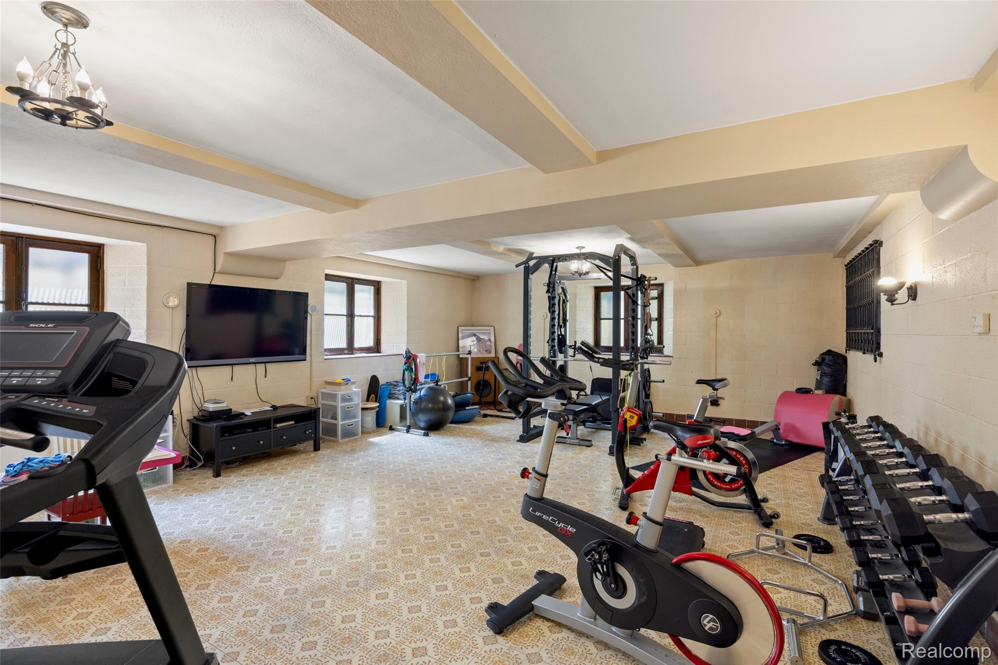 189 Cloverly Road Grosse Pointe, MI 48236 - Photo 62 of 93 Rare for a lower level, oversized windows fill this expansive recreation room with natural light, creating an inviting space for fitness, recreation, or entertaining.