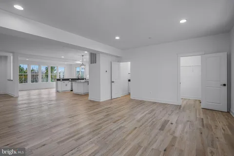 a view of empty room with wooden floor and a window