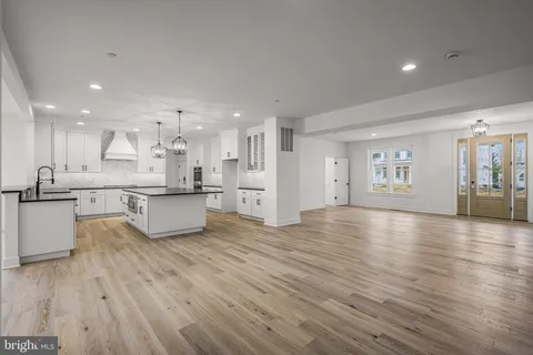 a large kitchen with stainless steel appliances kitchen island a large counter top a stove and a refrigerator