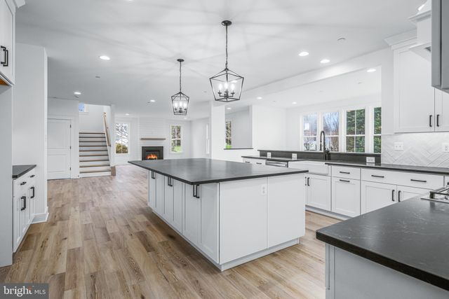 a kitchen with granite countertop a sink dishwasher a stove and a wooden floor