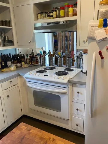 a kitchen with granite countertop white cabinets and window