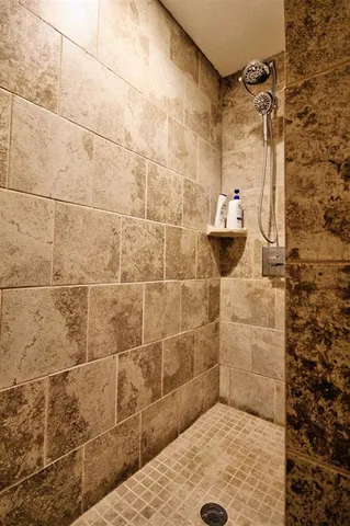an empty room with wooden floor chandelier fan and windows