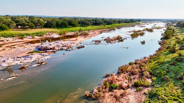 an aerial view of a houses with yard and lake view