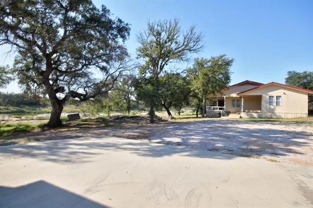 a view of backyard with outdoor seating and trees