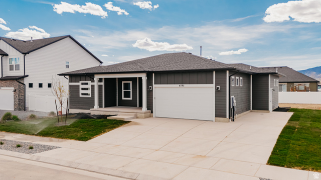 4595 North Fallow Way, Unit 511 Eagle Mountain, UT 84005 - Photo 10 of 32 View of front of house with roof with shingles, a garage, driveway, covered porch, and board and batten siding