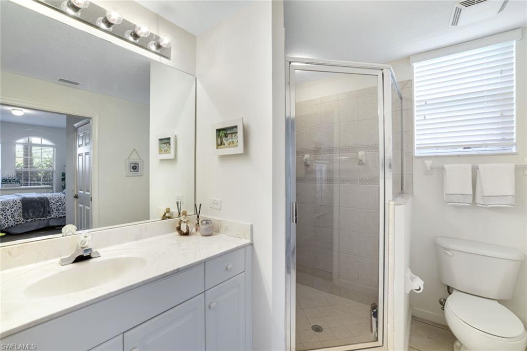 10049 Heather Lane, Unit 101 Naples, FL 34119 - Photo 20 of 28 Ensuite bathroom with vanity, a stall shower, and light tile patterned floors
