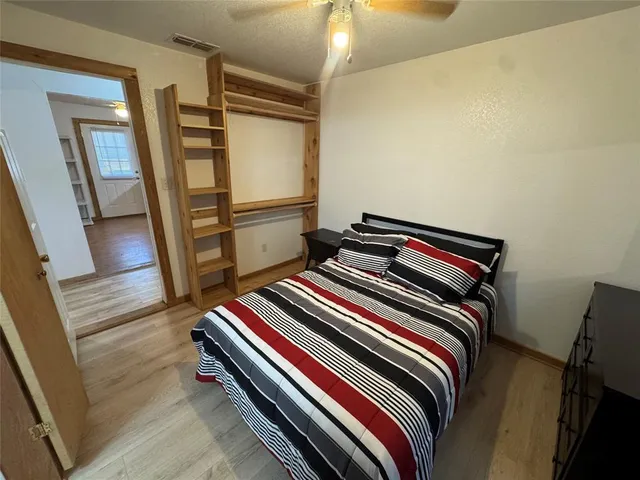 a bedroom with bed and wooden floor
