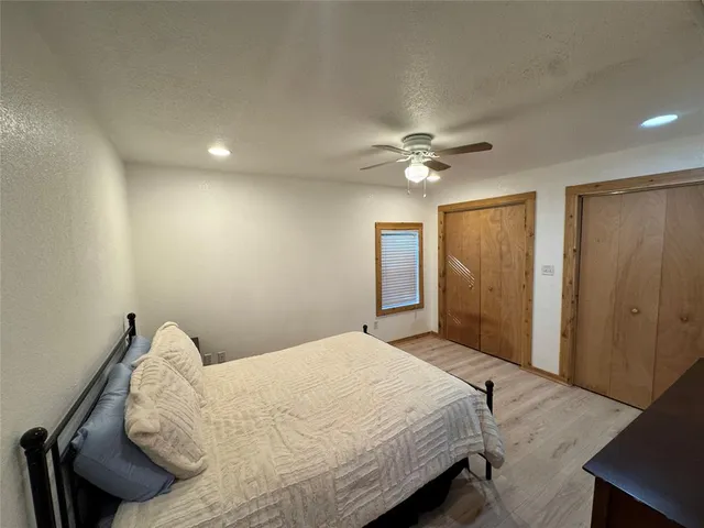 a bedroom with a large bed and a ceiling fan