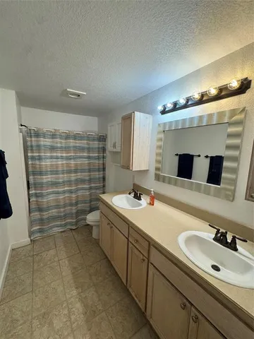 a bathroom with a double vanity sink mirror and bathtub