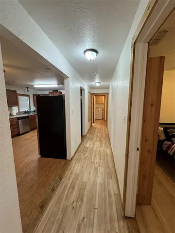 a view of a hallway with wooden floor and staircase