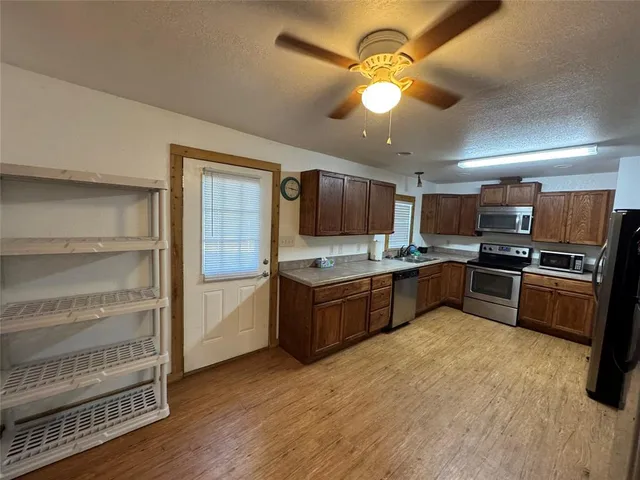 a large kitchen with a large counter top space appliances and cabinets