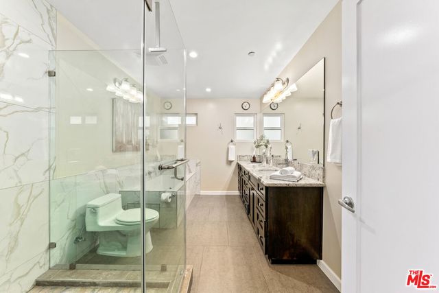 a bathroom with a sink mirror toilet and shower