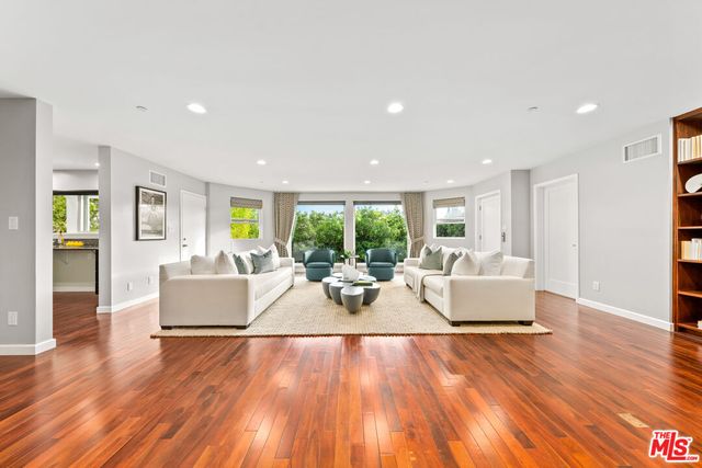 a living room with fireplace furniture wooden floor and a large window