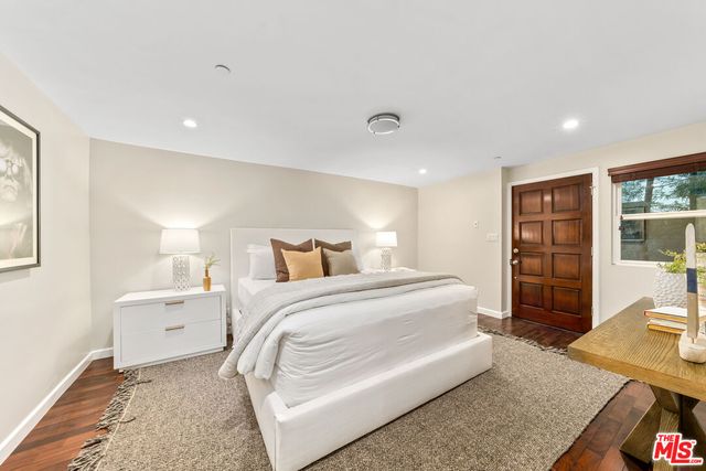 a spacious bedroom with a bed and a dresser