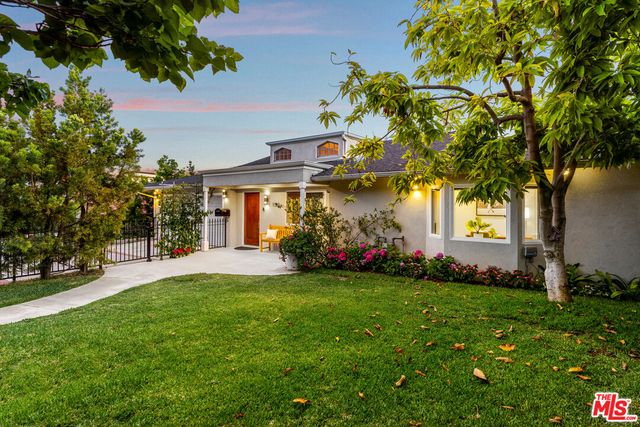 a view of a house with a big yard and potted plants