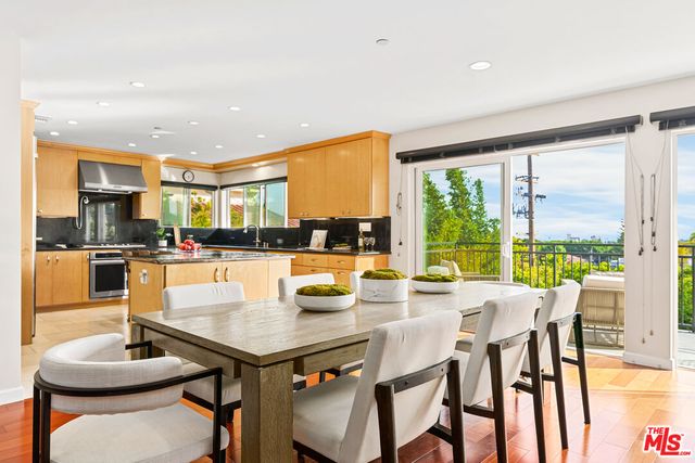 a dining room with stainless steel appliances granite countertop a table and chairs