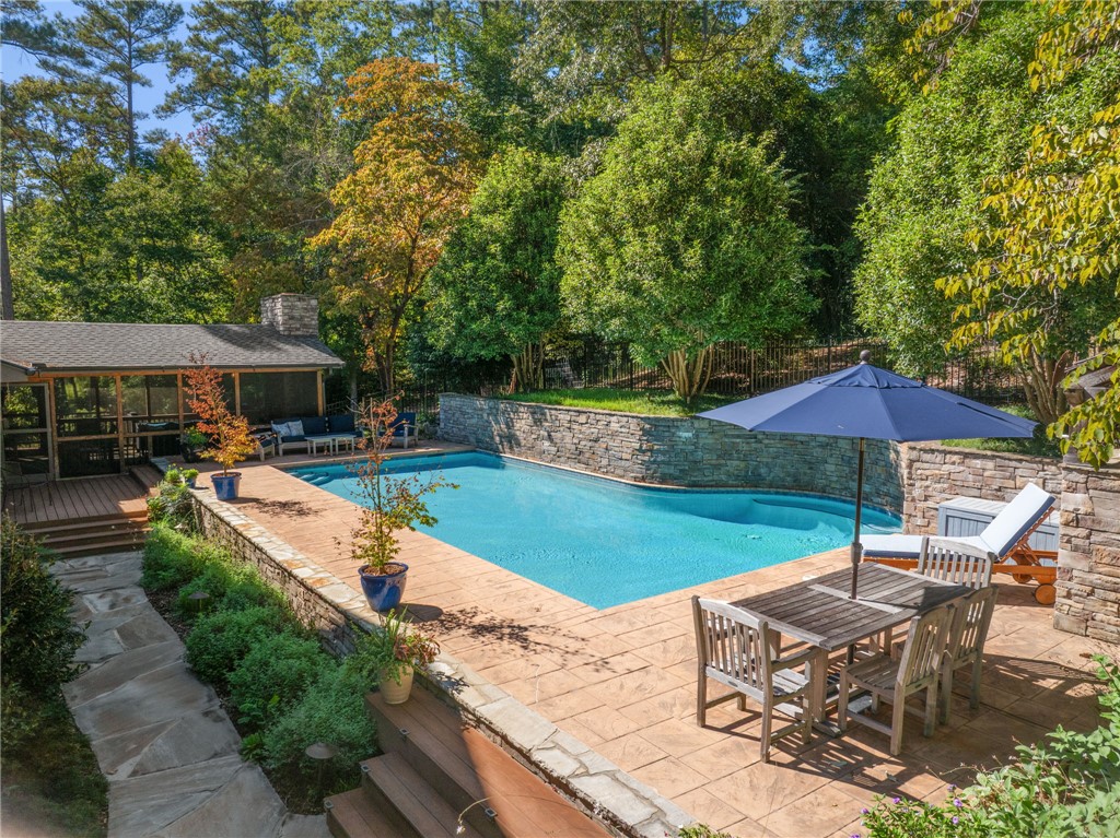 604 Ridgecrest Drive Clemson, SC 29631 - Photo 46 of 50 A sparkling swimming pool sits surrounded by stone-paved decking and mature trees.