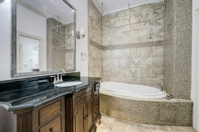 a bathroom with a granite countertop bathtub sink vanity and shower