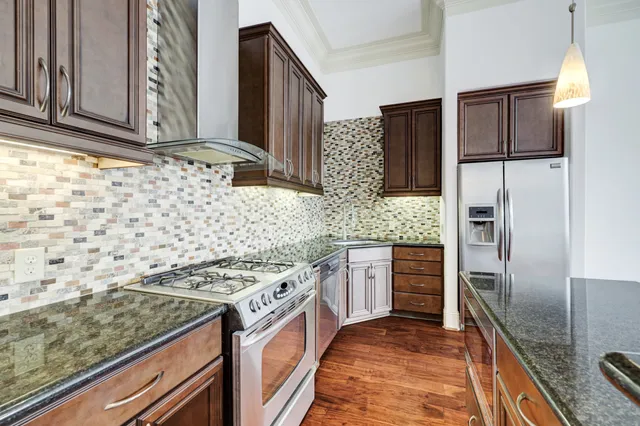 a kitchen with stainless steel appliances granite countertop a refrigerator and a stove
