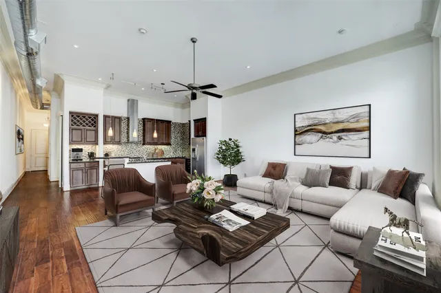 a living room with furniture kitchen view and a chandelier