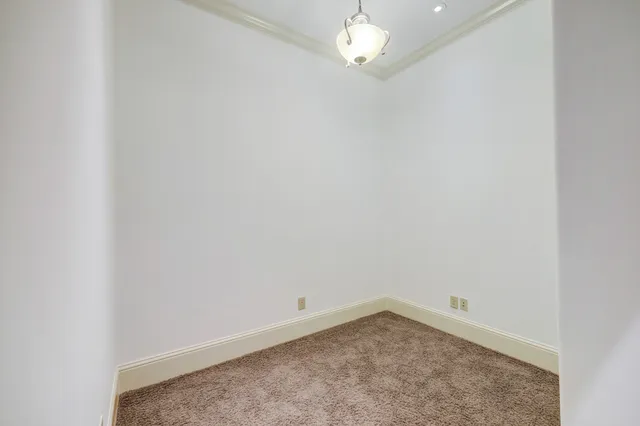 an empty room with a chandelier fan