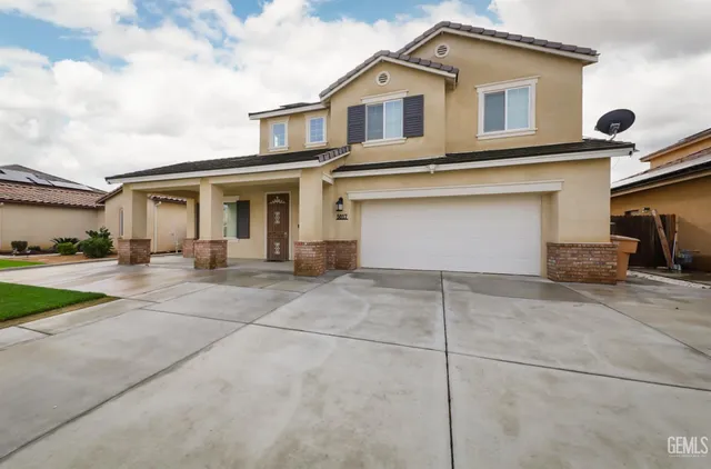 a view of white house with a yard and large parking space