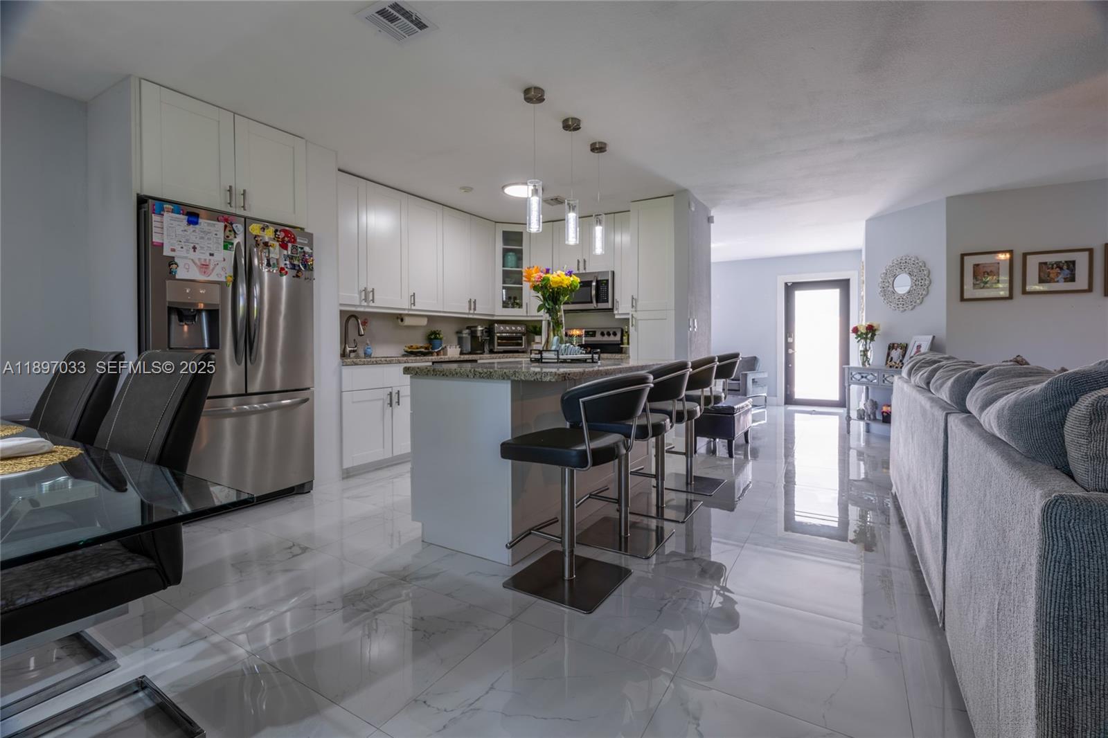 11381 Southwest 247th Terrace Homestead, FL 33032 - Photo 12 of 42 a kitchen with stainless steel appliances kitchen island granite countertop a refrigerator and microwave