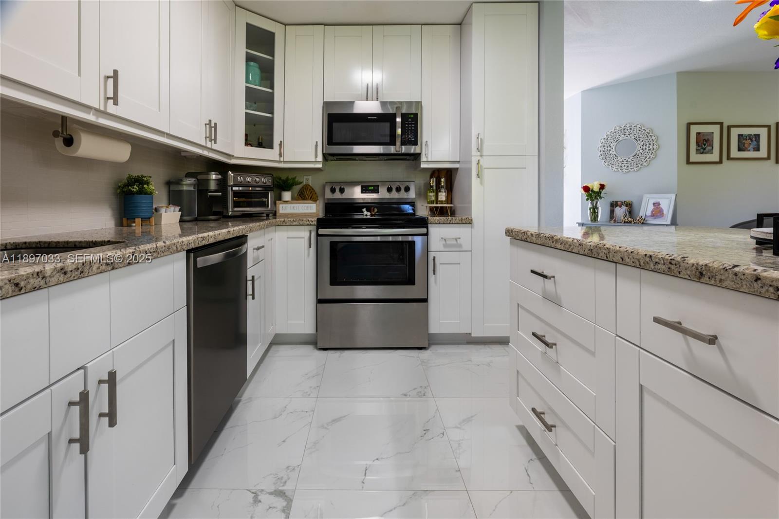 11381 Southwest 247th Terrace Homestead, FL 33032 - Photo 14 of 42 a kitchen with granite countertop a sink and steel appliances