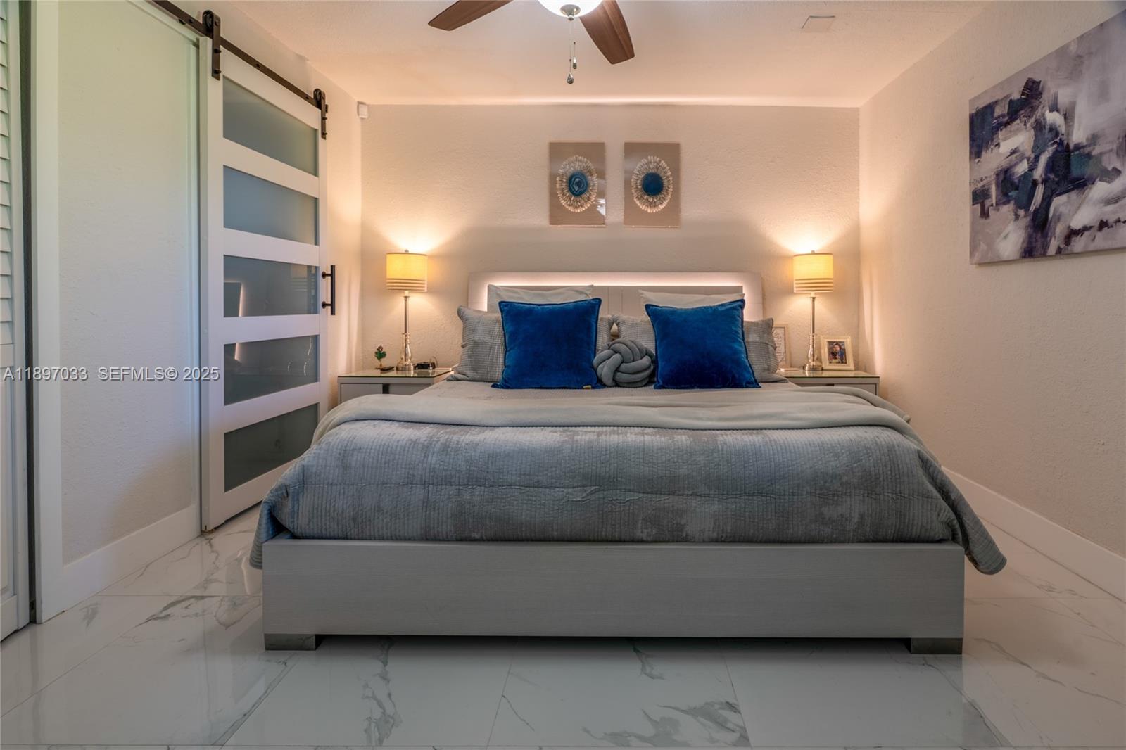 11381 Southwest 247th Terrace Homestead, FL 33032 - Photo 16 of 42 a bedroom with a bed and a chandelier