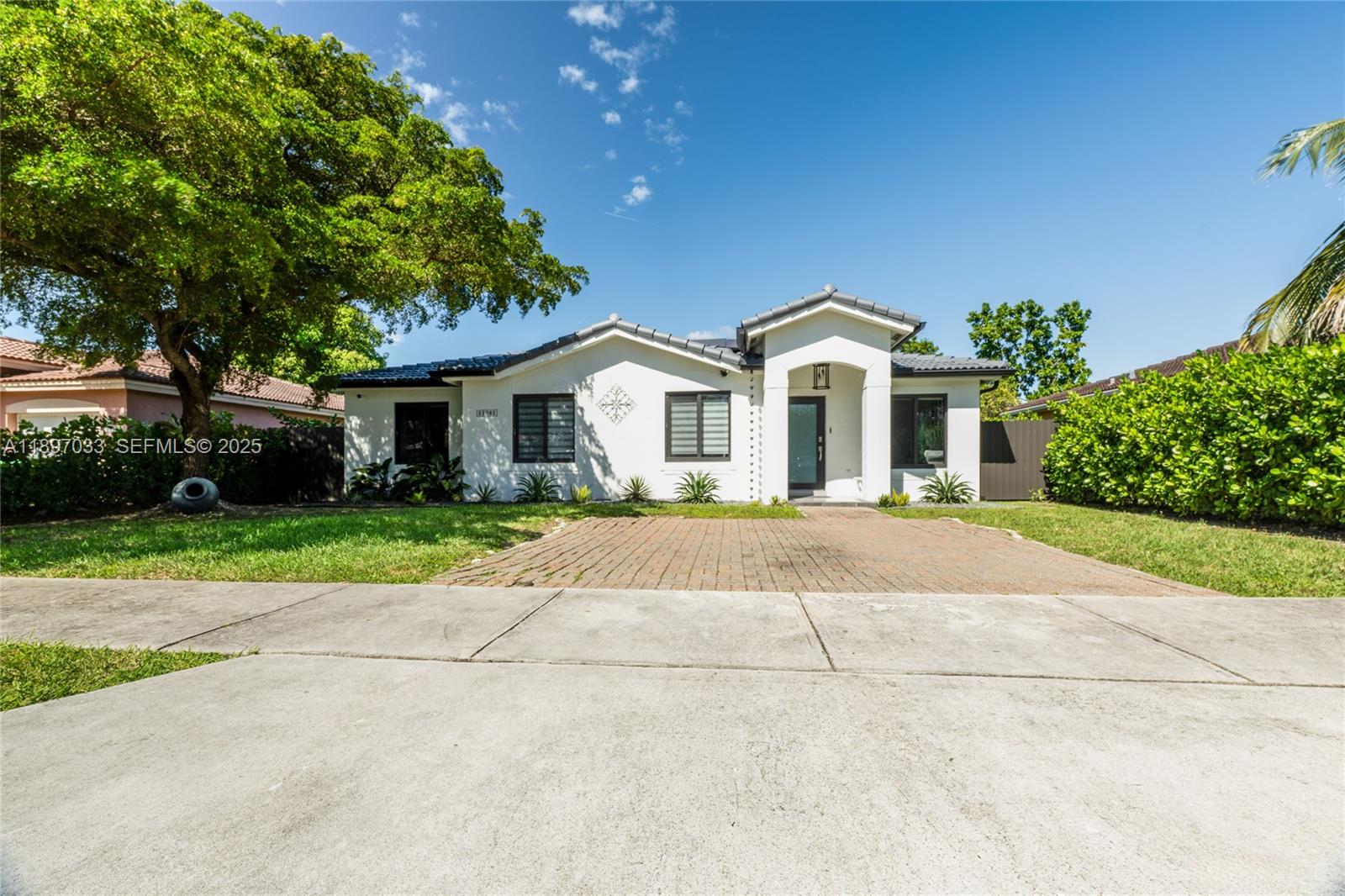 11381 Southwest 247th Terrace Homestead, FL 33032 - Photo 3 of 42 a front view of a house with a yard and a garage