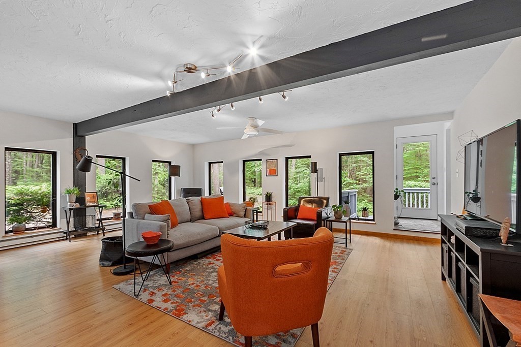 309 Littleton Road Harvard, MA 01451 - Photo 20 of 41 a living room with furniture tv and large windows
