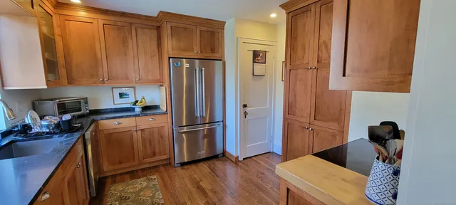 a kitchen with stainless steel appliances granite countertop a refrigerator and a stove top oven