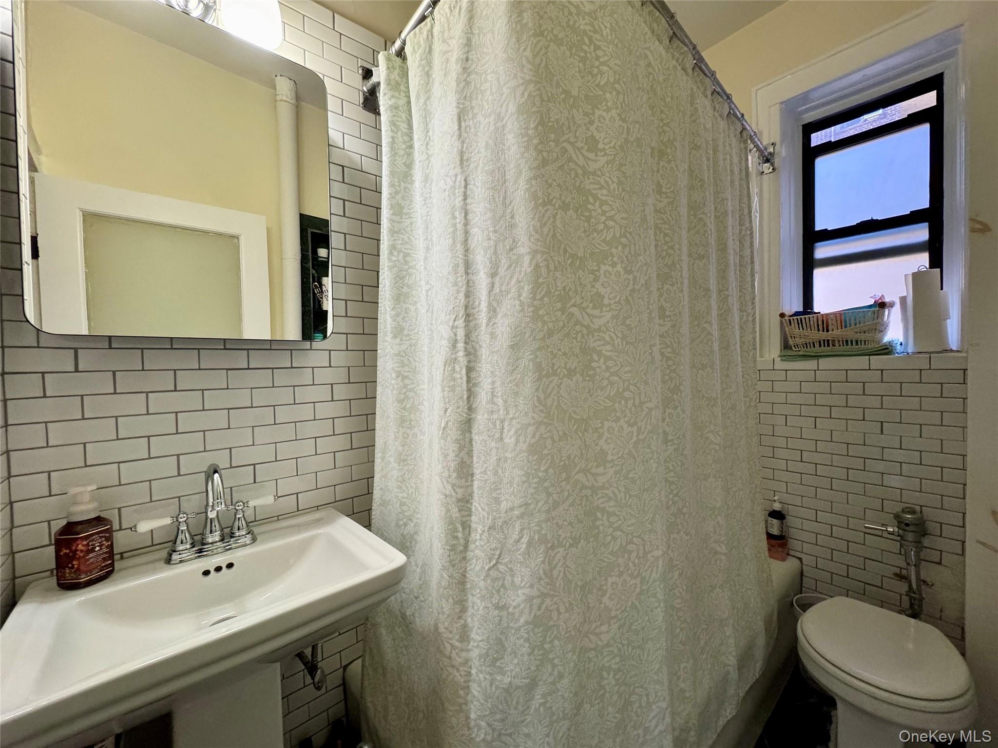 83-64 Talbot Street, Unit 3A Queens, NY 11415 - Photo 14 of 19 a bathroom with a sink a toilet and mirror