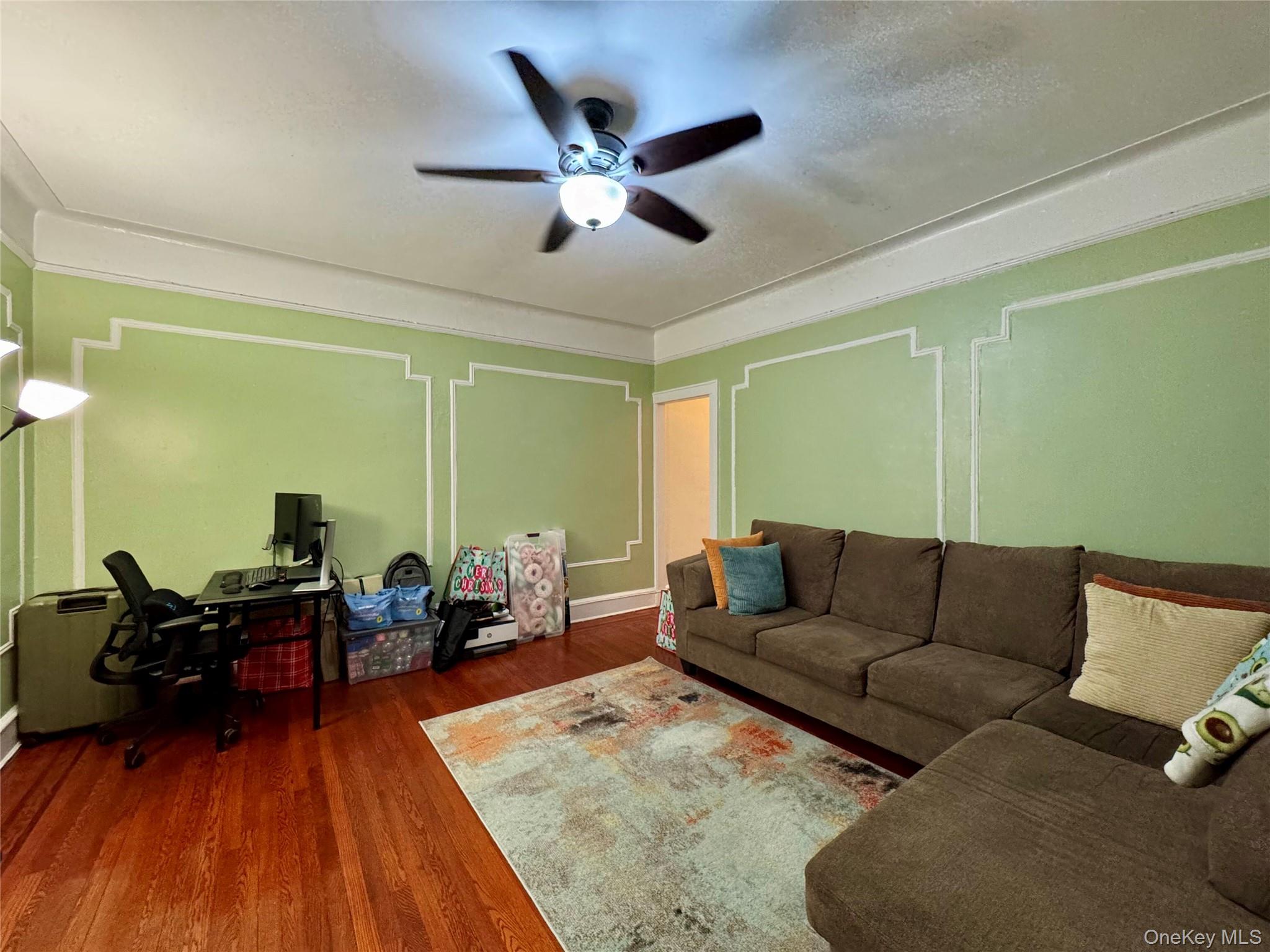83-64 Talbot Street, Unit 3A Queens, NY 11415 - Photo 17 of 19 Living room featuring dark wood-style floors, a ceiling fan, and an office area