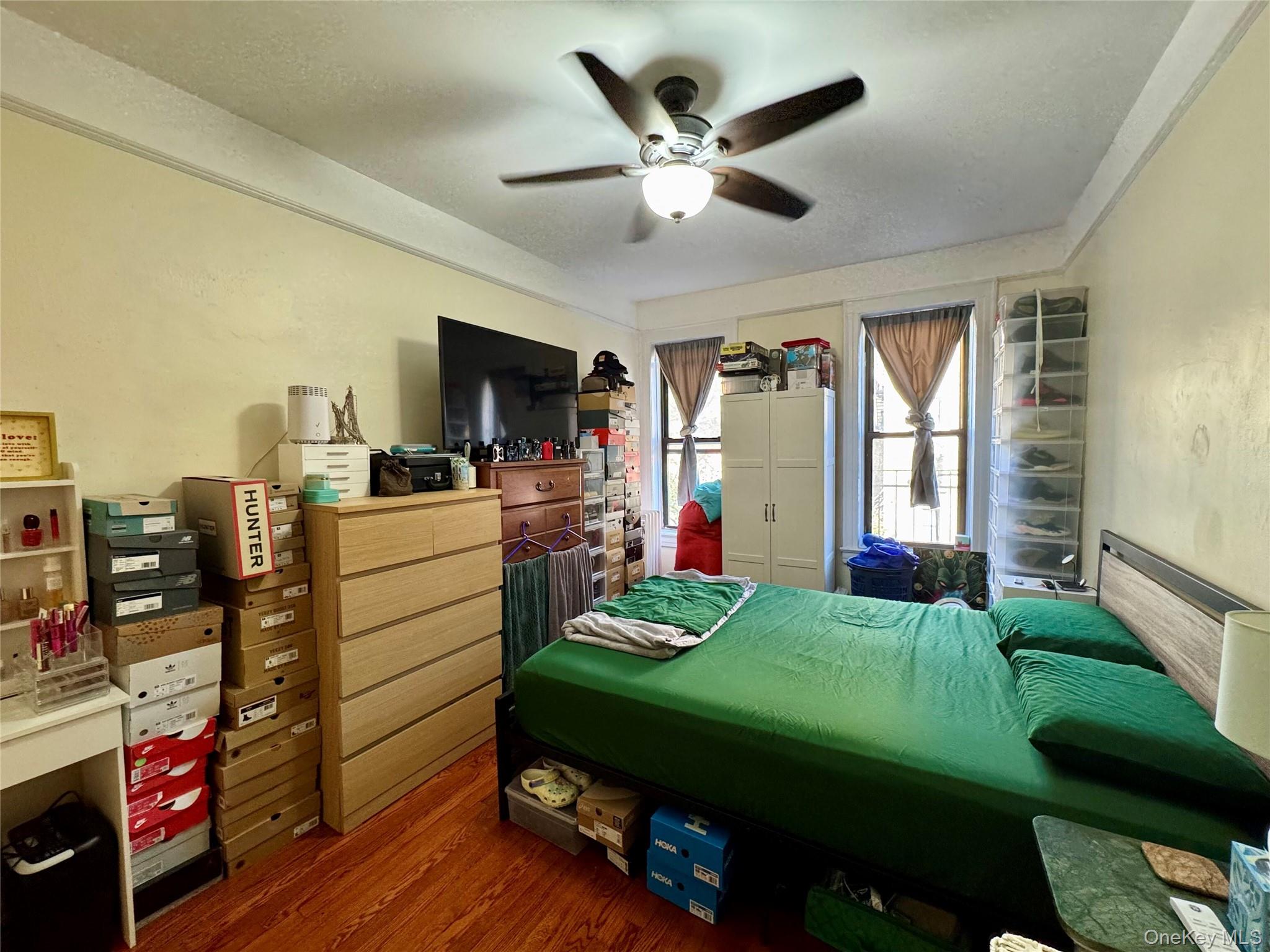 83-64 Talbot Street, Unit 3A Queens, NY 11415 - Photo 6 of 19 Bedroom featuring wood finished floors, a ceiling fan, and a textured ceiling