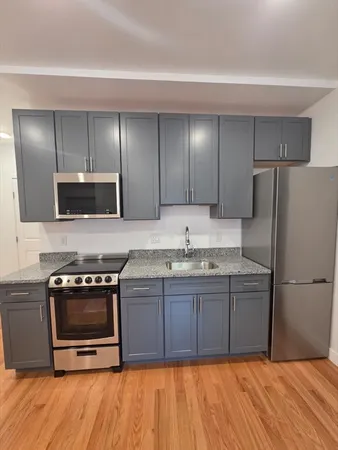 a kitchen with stainless steel appliances granite countertop a stove a sink and a refrigerator
