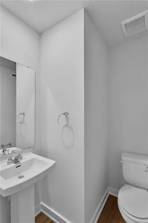 a bathroom with a sink a toilet and mirror