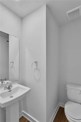 a bathroom with a sink a toilet and mirror